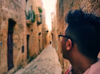 Young man amidst buildings