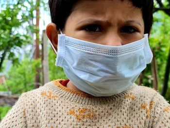 Close-up portrait of girl wearing mask standing outdoors