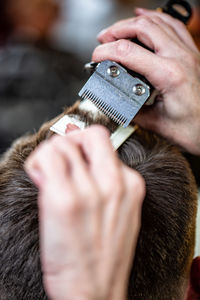 Cropped hands of barber cutting customer hair