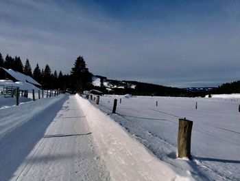 Snow covered field against sky