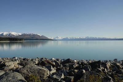 Scenic view of lake against clear blue sky