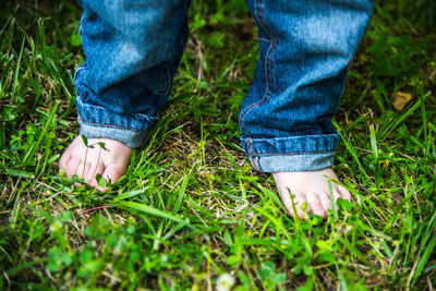 Low section of woman standing on grassy field