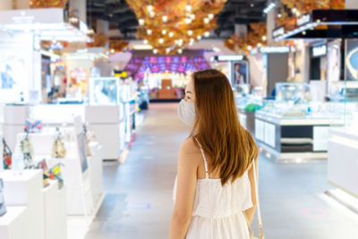 Woman with mask standing at store