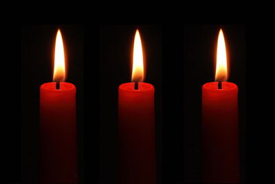 Close-up of lit candles in darkroom