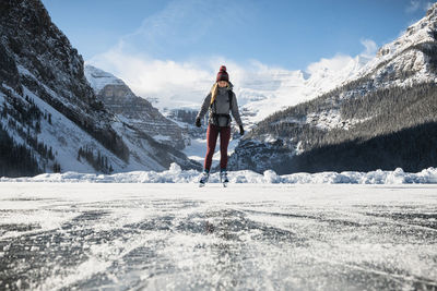 Man standing on snowcapped mountain against sky