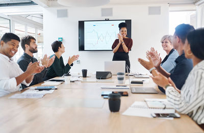 A business group clapping in a boardroom meeting. colleagues celebrating success at a presentation