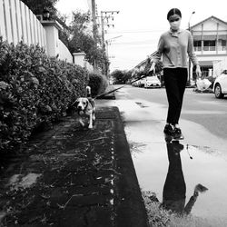 Asian female walking her dog in the village on saturday evening