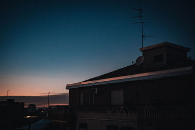 Silhouette building against clear sky during sunset