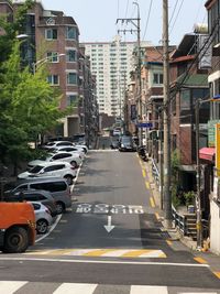 Cars on road by buildings in city