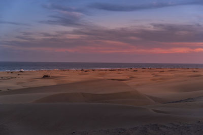 Scenic view of beach against sky during sunset