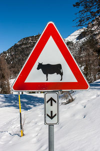 Road sign against sky during winter