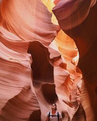 Low angle view of man looking at antelope canyon