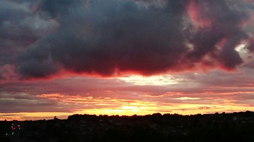 Silhouette of landscape against cloudy sky