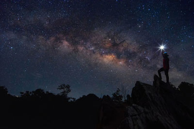 Silhouette man standing against star field at night