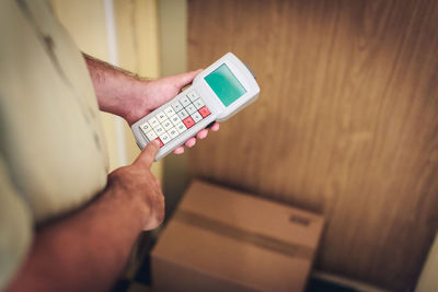 Midsection of man using mobile phone