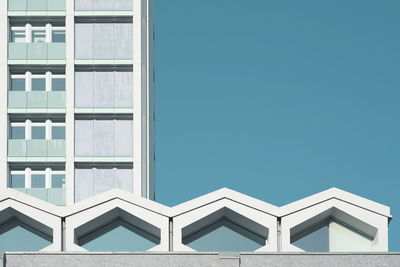 Low angle view of modern building against clear blue sky