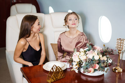 Beautiful happy women chatting and laughing while celebrating at table