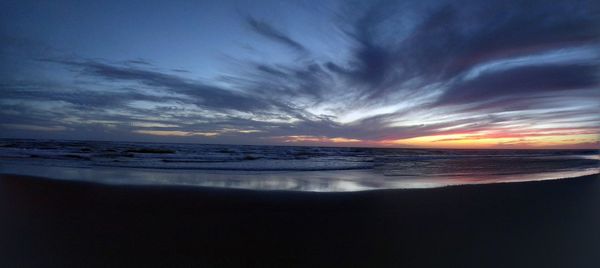 Scenic view of sea against dramatic sky during sunset