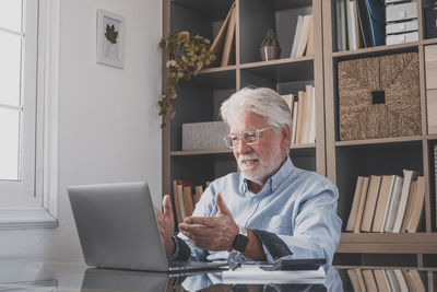 Senior businessman attending video conference at office