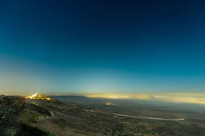 Scenic view of landscape against blue sky at night