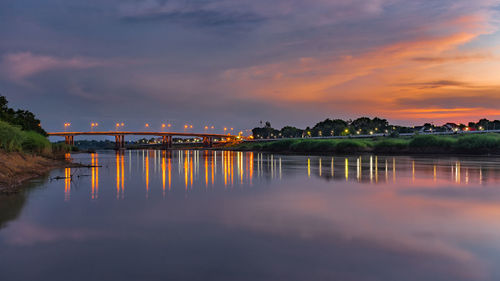 Bridge over river against sky at sunset