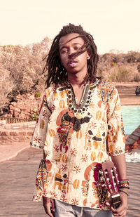 Portrait of boy with dreadlocks holding guitar