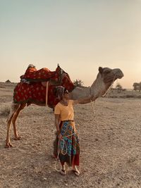 Rear view of woman standing on field against sky