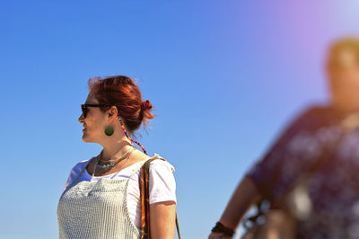 Low angle view of woman standing against clear sky