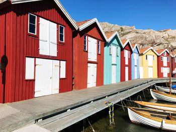 Houses on beach by building against sky