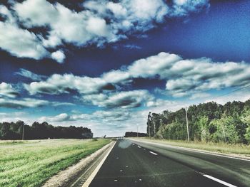 Empty road against cloudy sky