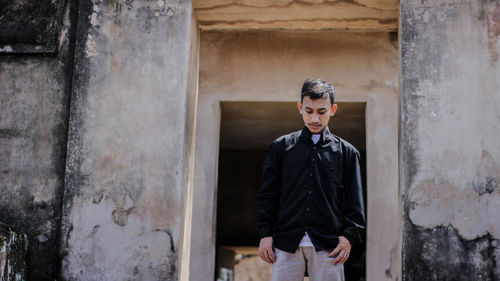 Young man standing against wall