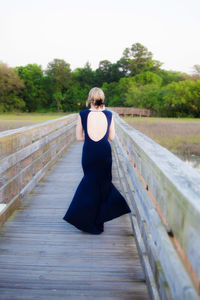 Rear view of woman walking on boardwalk