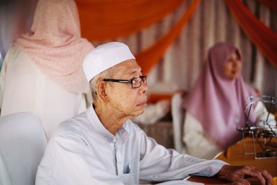 Senior man with woman in traditional clothing at table