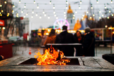 People in christmas market at evening. winter holidays and concept.