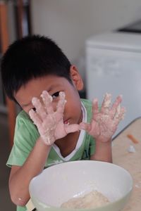 Portrait of boy holding ice cream in bowl on table