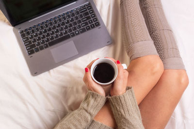 High angle view of woman holding coffee cup