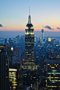 Illuminated buildings in city at dusk