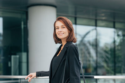 Portrait of young woman standing in city