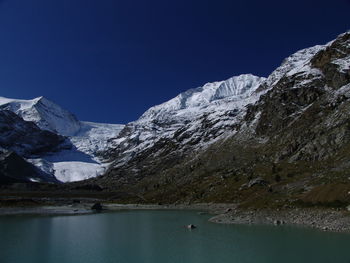 Scenic view of snowcapped mountains against clear blue sky