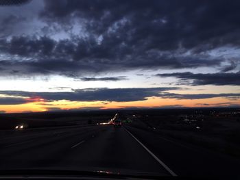 Road passing through dramatic sky at sunset