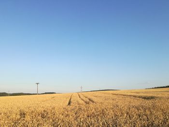 Scenic view of agricultural field against clear blue sky