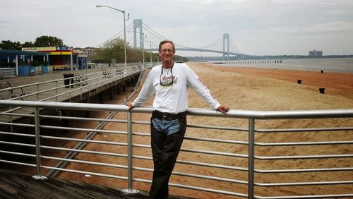 Portrait of a young man standing on railing