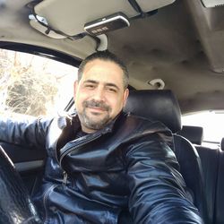 Portrait of happy man sitting in car