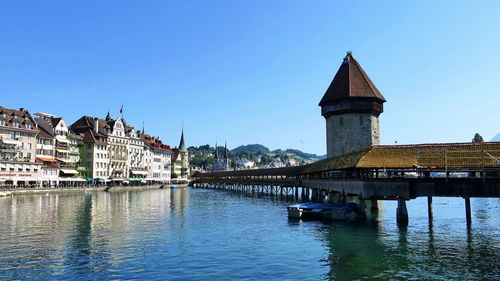 Bridge over river against buildings in city