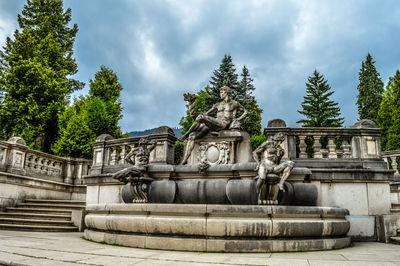 Sculptures at park against cloudy sky