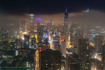 Illuminated cityscape against sky at night