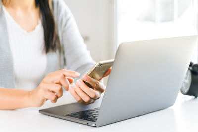 Midsection of woman using mobile phone