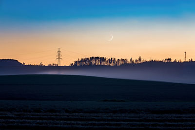 Scenic view of silhouette field against sky during sunset