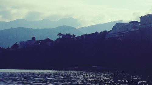 Scenic view of lake by mountains against sky