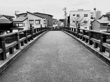 Empty footpath amidst buildings in city